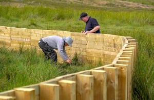 Image shows construction taking place on one of the timber fences