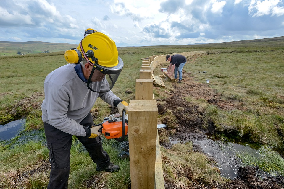 Image shows construction taking place on one of the timber fences 
