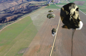 Paratroopers drop from a C-130 transport plane