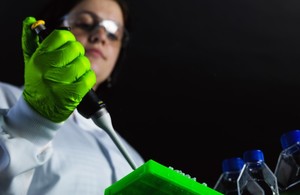 Shot of researcher in white coat from glass shelf below