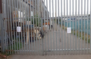 The image shows the lock and notice on the closed gates at the site