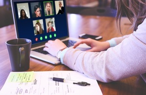 Woman working from home using laptop for video conference with colleagues