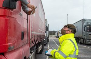 A Reserve soldier checks details of a lorry driver at Covid testing site.