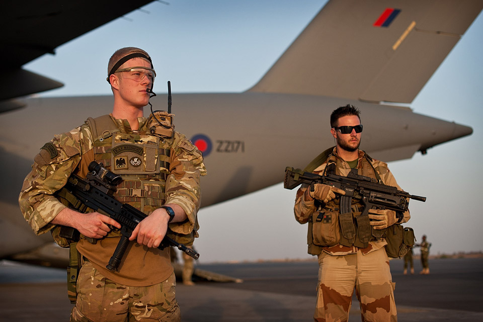 A Royal Air Force Regiment gunner (left) guarding an RAF C-17