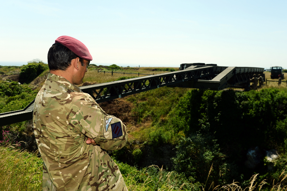 Commanding officer watches the construction of a 100-foot Medium Girder Bridge