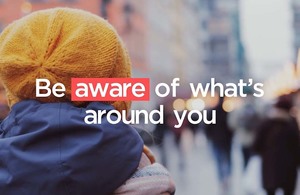 Back of person’s head with woollen hat on and blurred background, and the words “Be aware of what’s around you” overlaid.