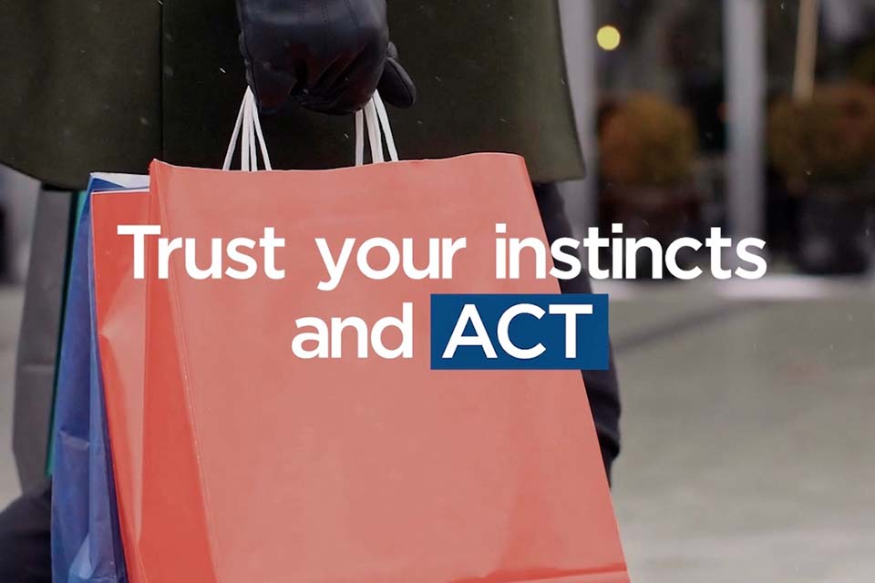 Hand holding shopping bags with blurred background and the words “Trust your instincts and ACT” overlaid.