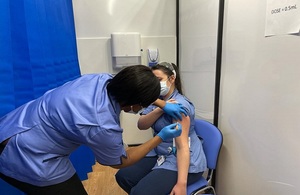 A nurse vaccinating another nurse
