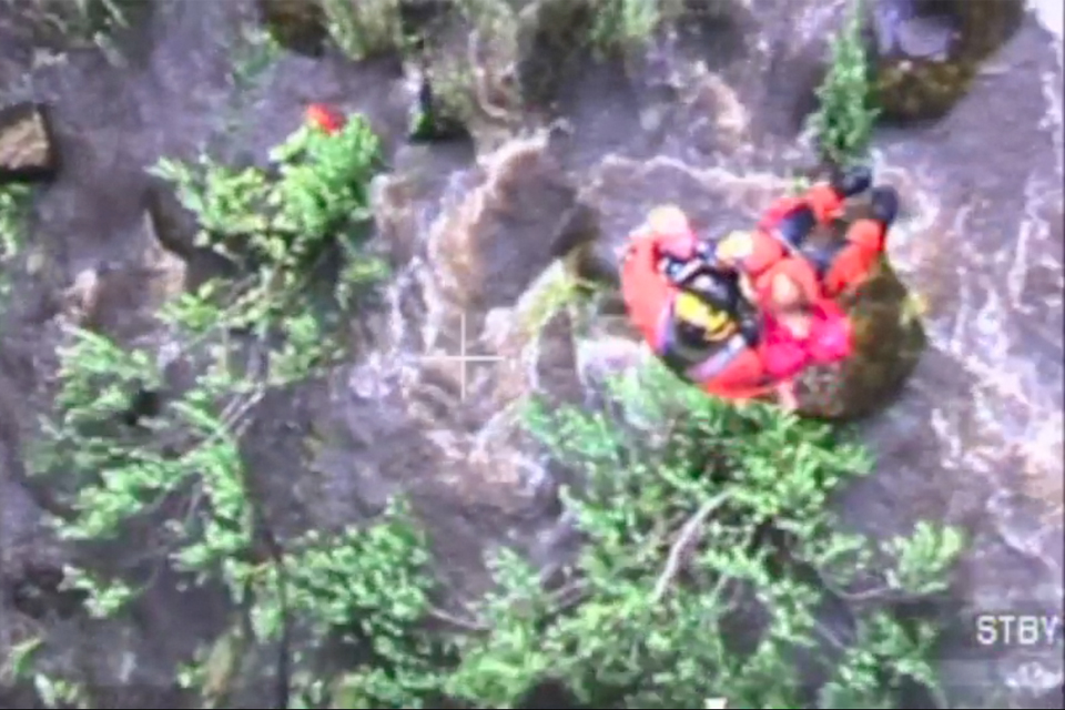 An RAF winchman is lowered over the River Ure