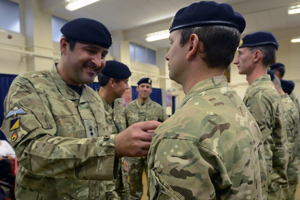 Colonel Adrian Thurgood presents a member of 159 Supply Regiment with his Operational Service Medal