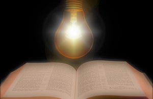 Электрическая лампочка, сияющая над книгой