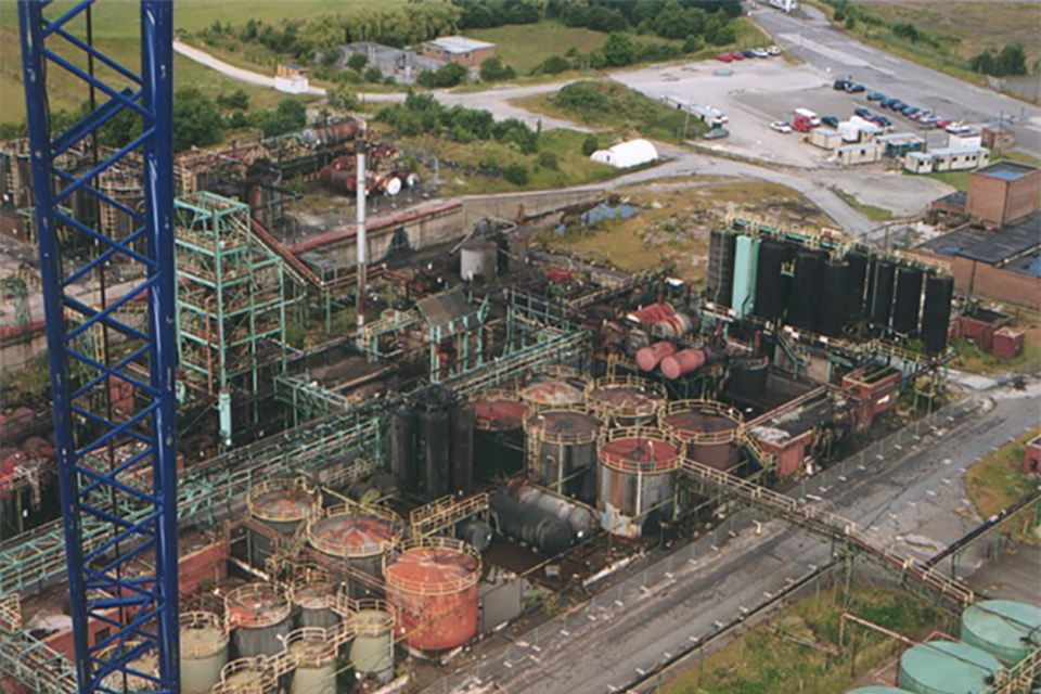 Вид с воздуха на коксохимический завод на проспекте перед рекультивацией.  Промышленная зона с множеством складских и нефтеперерабатывающих сооружений.