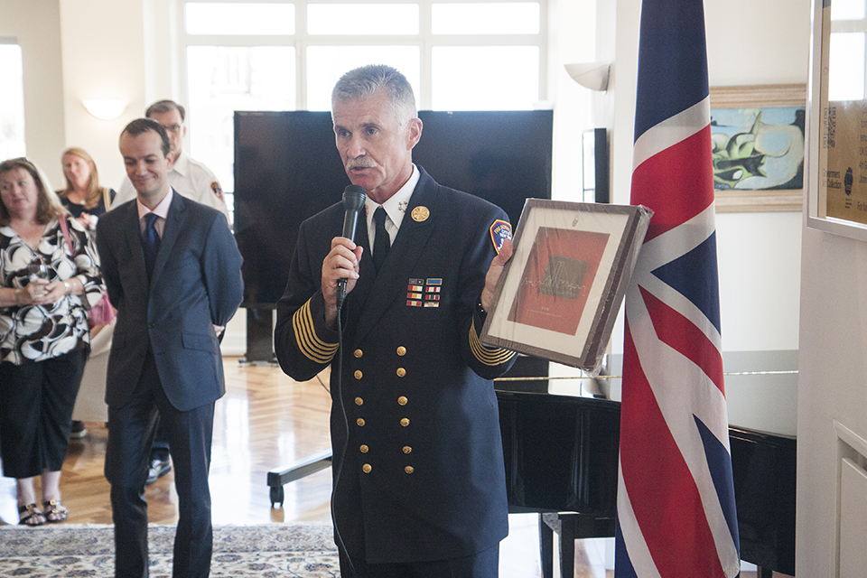 Chief of Department Edward Kilduff from the Fire Department of New York presents Consul General Lopez with a piece of steel from the World Trade Center.