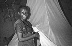 A pregnant Kenyan woman prepares to climb under an insecticide-treated bednet