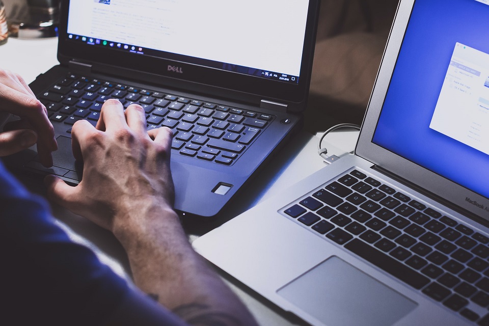 Man Working on Two Laptops at Once