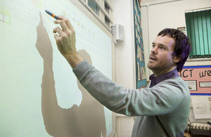 Teacher pointing at an interactive whiteboard.