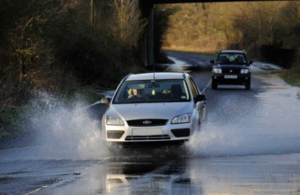 Image of car driving through flood water