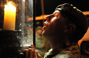 Lance Corporal Dale Leadbetter extinguishes the flame of a candle that had been kept lit outside the entrance to Battlesbury Barracks from the time the first of 3 YORKS' companies deployed to Afghanistan back in February