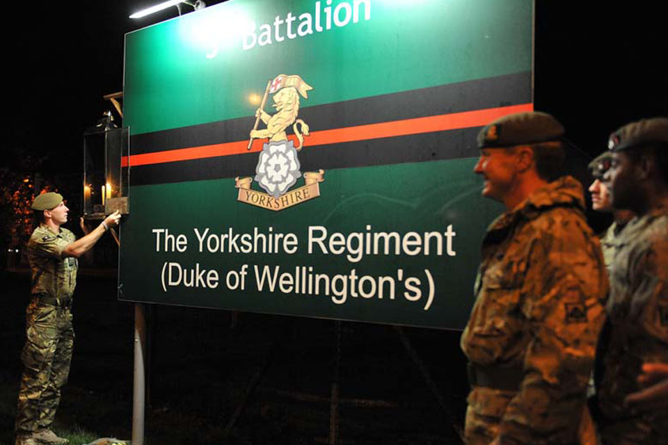 Members of the battalion and Commanding Officer Lieutenant Colonel Zac Stenning watch Lance Corporal Dale Leadbetter extinguish the flame of the candle which had been kept lit since February