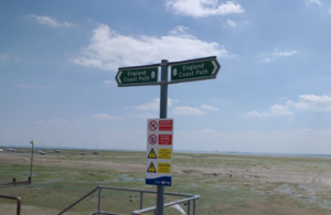 Coast path sign and view out to sea