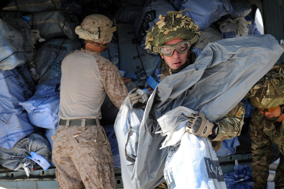 Soldiers offload bags of Christmas mail from a helicopter