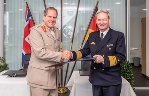 Генерал-лейтенант Копинг-Саймс обменивается рукопожатием с вице-адмиралом доктором Томасом Даумом.