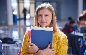 Студентка уровня A, стоящая с книгой в руке