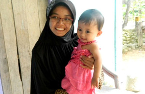 Project worker Intan with Santi's baby daughter Cerah Kamila.