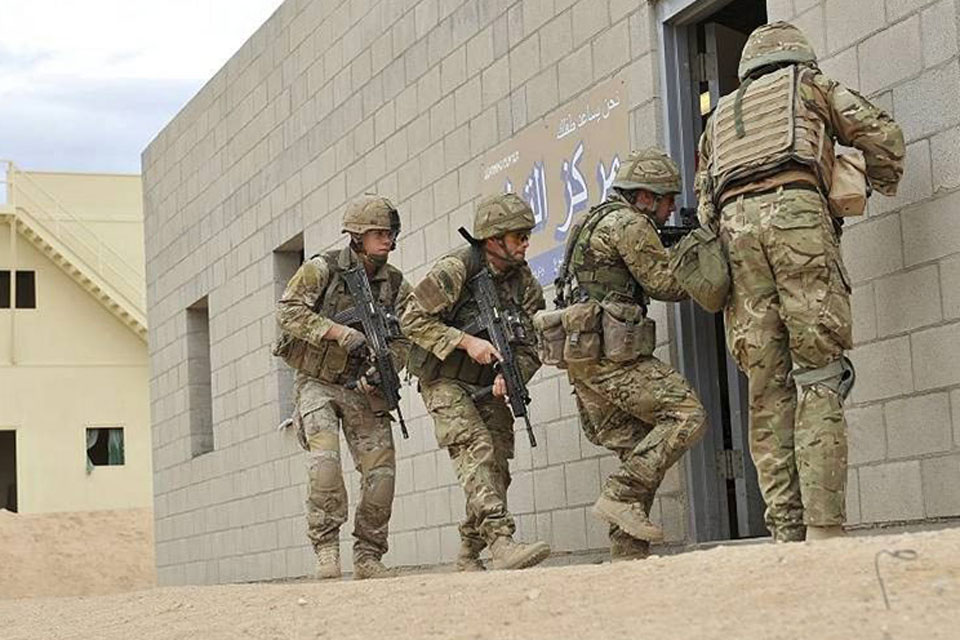 Royal Marines commandos enter a compound at the US Marine Corps Air Ground Combat Center, also known as Twentynine Palms, in California