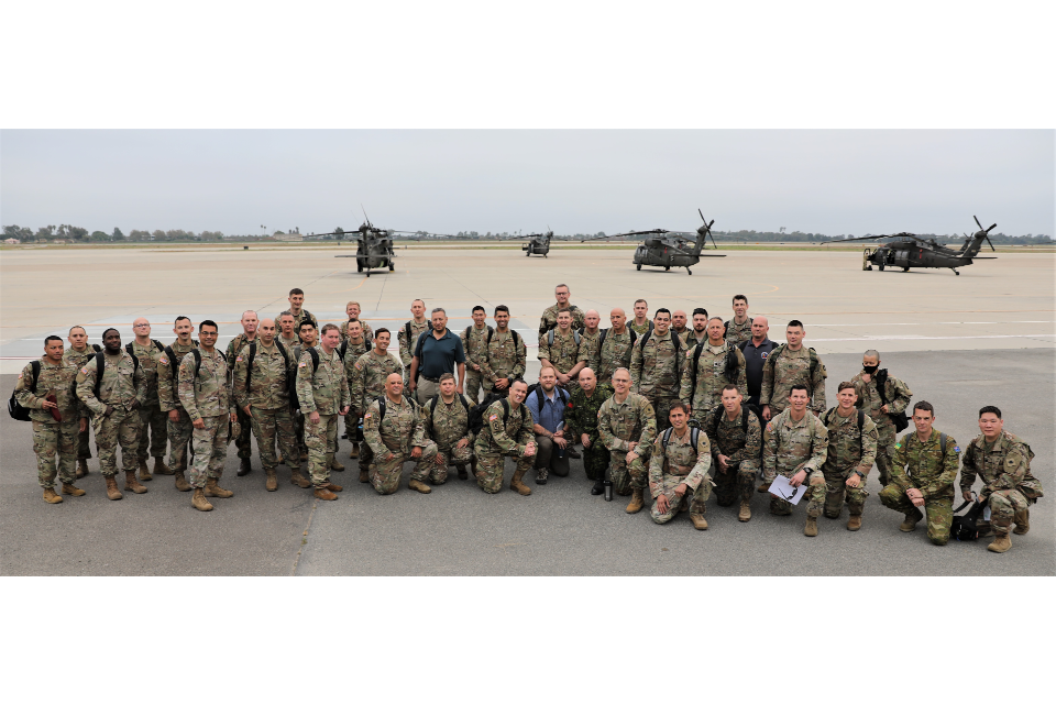 Group photo of course attendees with helicopters in the background