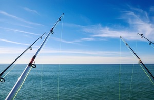 Four fishing rods and open blue sea scape.