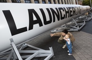 Мужчина и маленький ребенок указывают на ракету