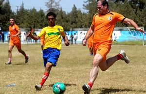 The 'Helmand Olympics' football competition between Afghan and British forces (playing in orange) at the Karzai Stadium in Lashkar Gah