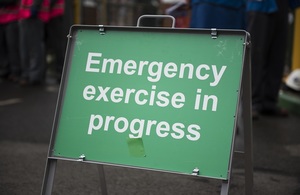 Зеленый уличный знак с надписью «Идут аварийные учения»