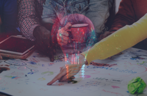 An image of a lightbulb on top of an image of a group pointing at a poster