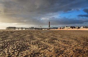 Blackpool tower and Blackpool beach is pictured. The sand is in the foreground with the tower, pier and funfair in the background,