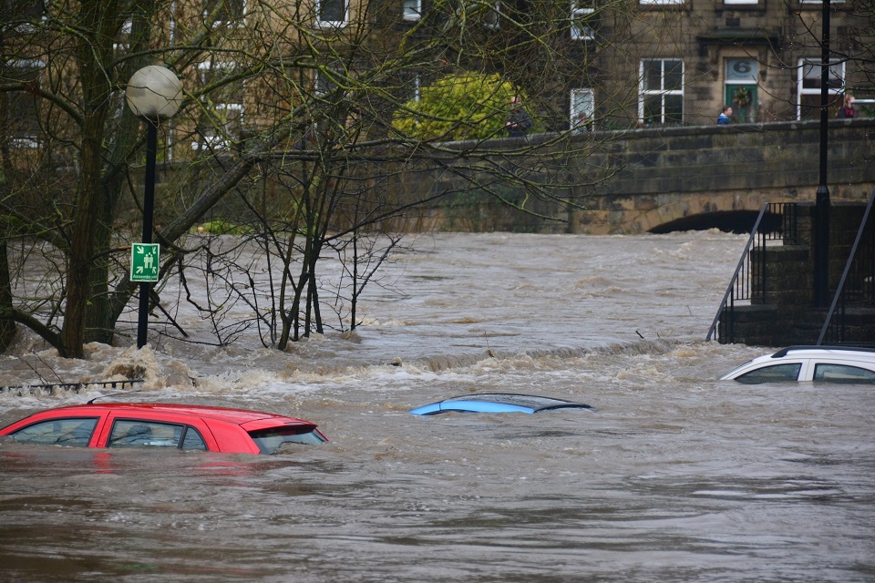 Cars submerged in floodwater. Just the roofs of 3 cars are visible.