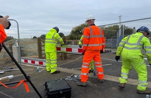 A group of staff from the Environment Agency and Jackson Civil Engineering put up a demountable flood barrier