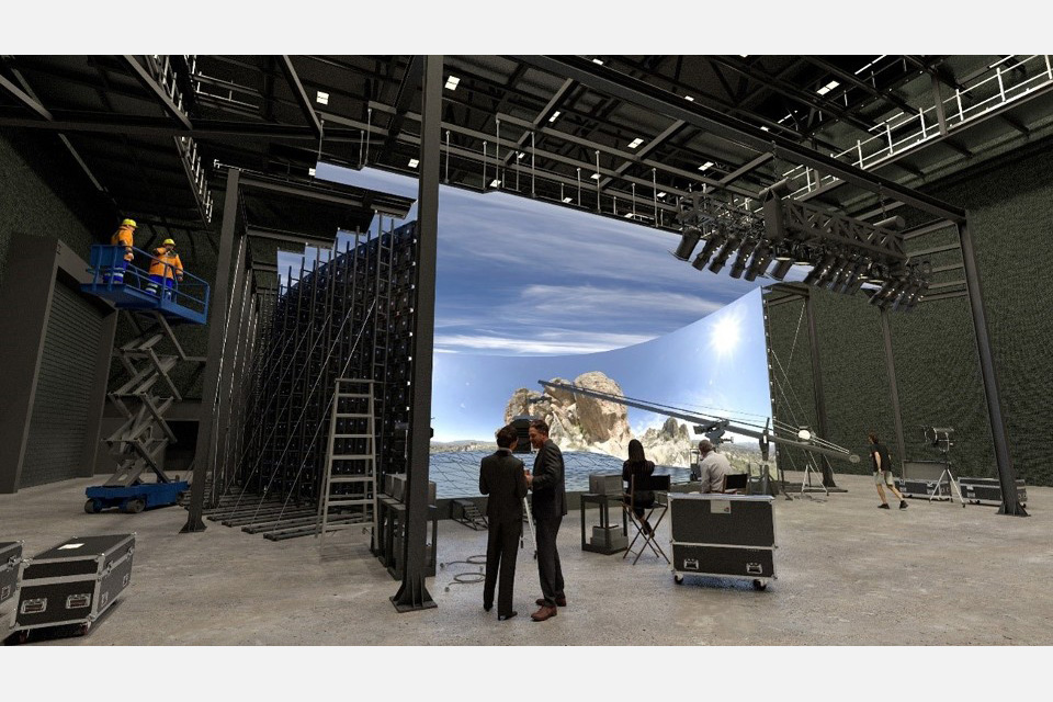 Wide view of a film studio set with cameras, lights and a boom.