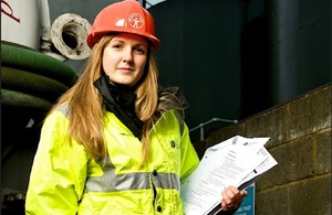 Сотрудник Агентства по охране окружающей среды держит планшет во время инспекции на рабочем месте.