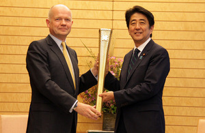 British Foreign Secretary William Hague and Japanese Prime Minister Shinzo Abe hold a London 2012 Olympic torch as a symbol of UK-Japan collaboration.