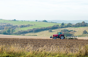 red tractor ploughing a field with birds picking up worms