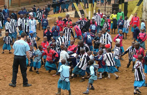 Senior Aircraftman Ben Burton plays football with children at the Kibagare Good News Centre in Kenya