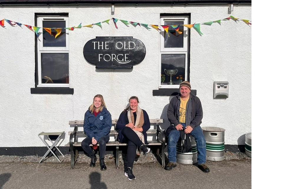 People sitting outside the Old Forge pub in the village of Inverie