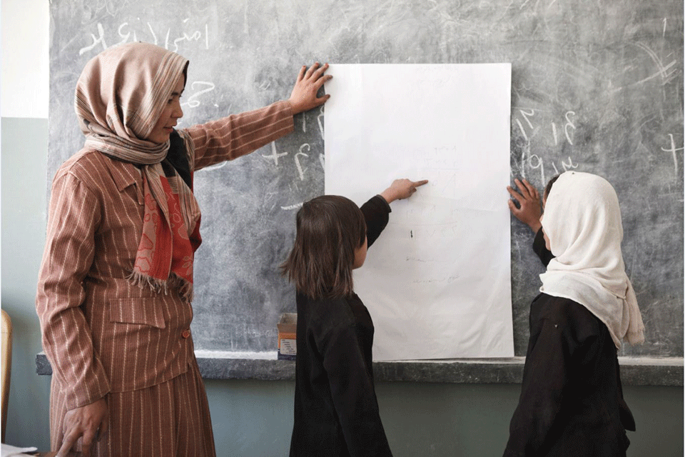 Teacher and pupils in classroom.