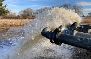 Photo of pipes discharging a big spray of water into a river