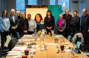 A picture of the members of the commission standing around a table and posing for the camera.