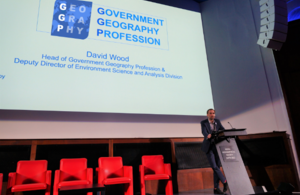 David Wood, Head of Government Geography Profession standing behind a lecturn