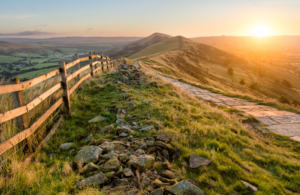 A stone footpath and wooden fence leading along the Great Ridge in the Peak District