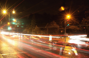 Traffic lights on a road at night.